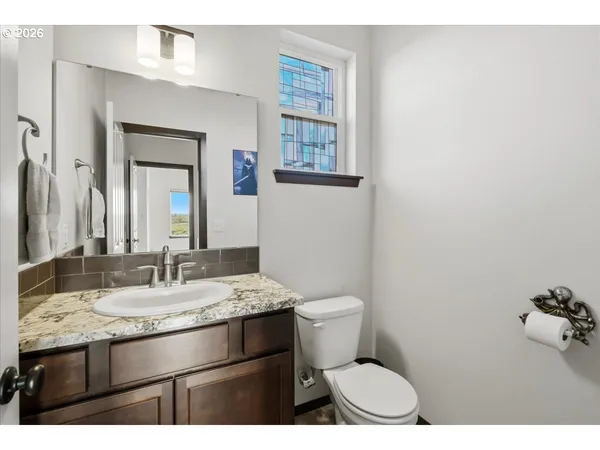 a bathroom with a granite countertop toilet sink and mirror