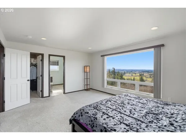 a bedroom with a bed and a large window