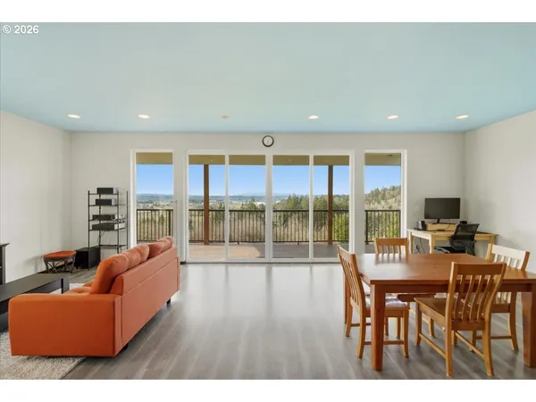 a living room with furniture a floor to ceiling window and outdoor view