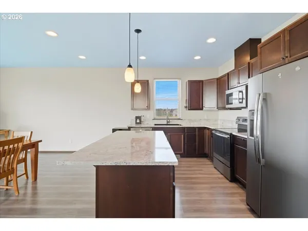 a kitchen with kitchen island stainless steel appliances sink cabinets and stove