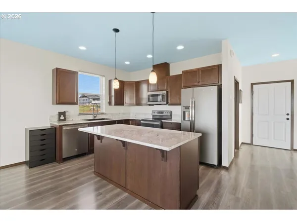 a kitchen with stainless steel appliances granite countertop a sink a stove a refrigerator and a microwave