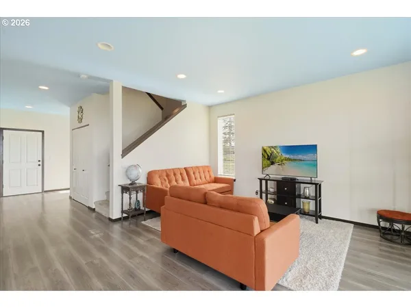 a living room with furniture and a wooden floor