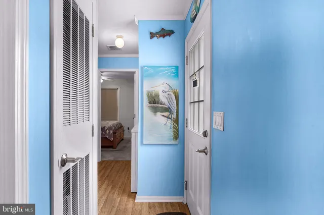 a view of a hallway with wooden floor and livingroom