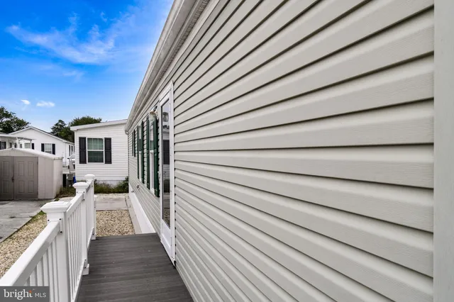 a view of a house with a barbeque and wooden stairs