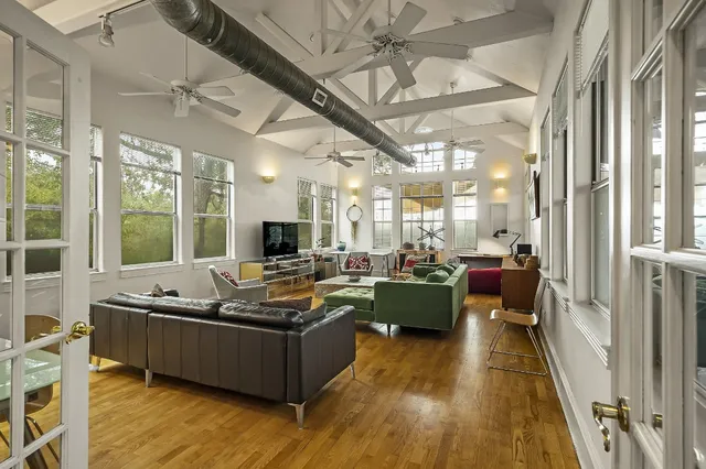 a living room with furniture fireplace and large windows