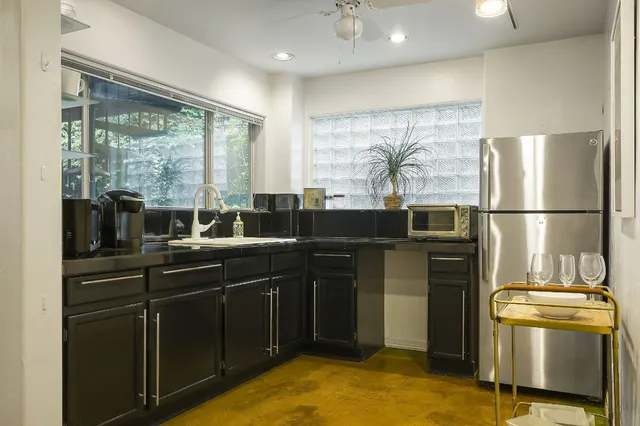 a kitchen with stainless steel appliances granite countertop a refrigerator and a sink