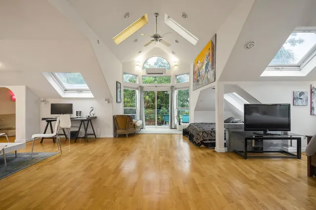a view of a livingroom with furniture a flat screen tv and windows
