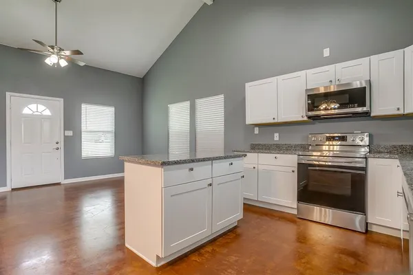 a kitchen with granite countertop white cabinets and white appliances