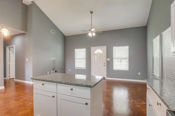 a kitchen with stainless steel appliances granite countertop a stove a sink dishwasher and a microwave oven with white cabinets