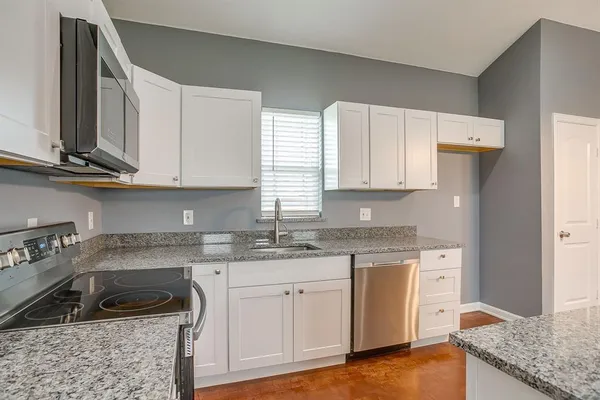 a spacious bathroom with a granite countertop sink a mirror and shower