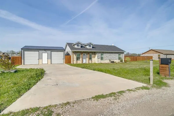 a front view of a house with a garden and yard