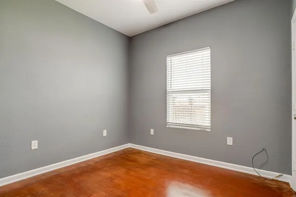 an empty room with wooden floor and entrance