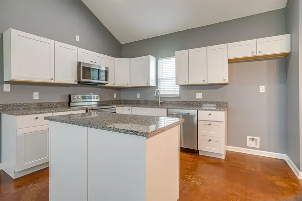 a kitchen with stainless steel appliances granite countertop a sink stove and cabinets