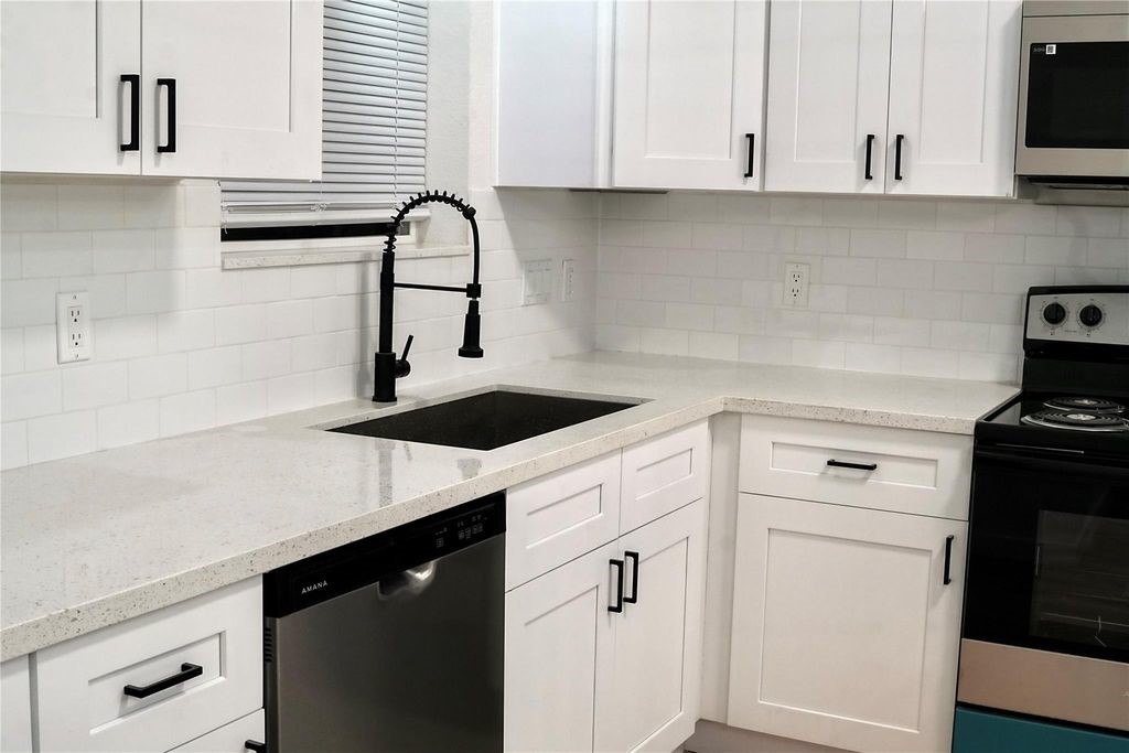 9705 Garcroft Street, Unit A Houston, TX 77029 - Photo 2 of 12 a kitchen with granite countertop white cabinets and appliances