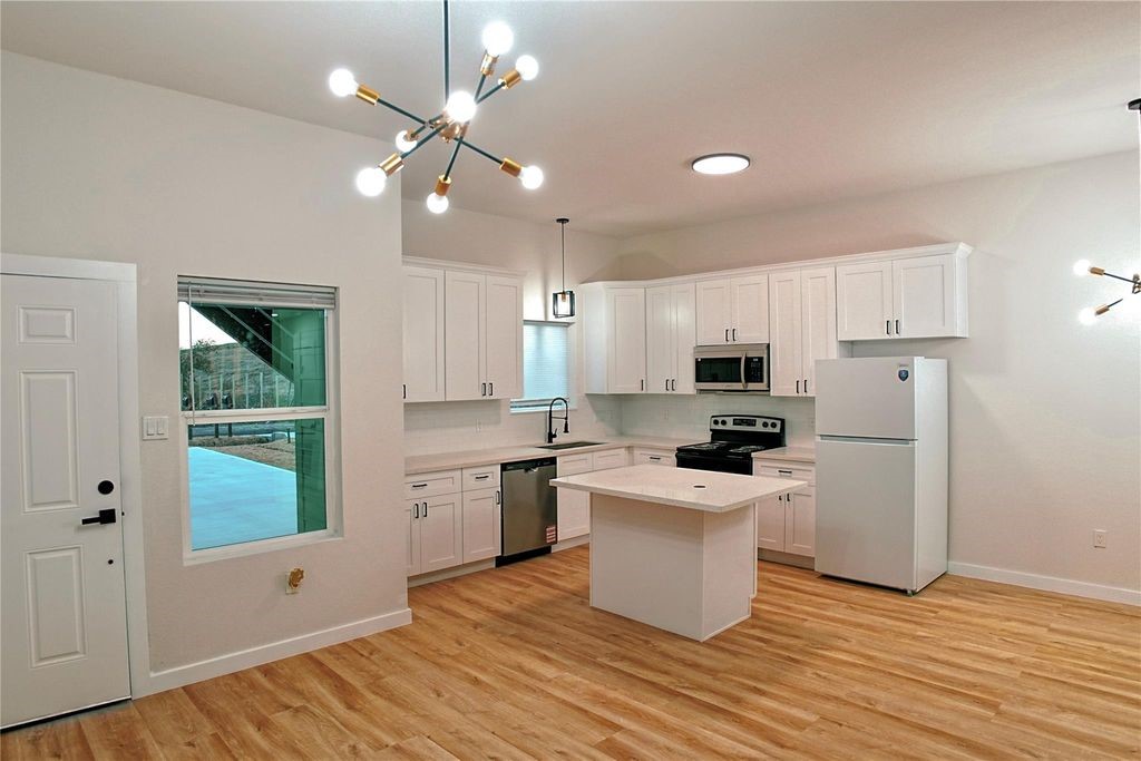 9705 Garcroft Street, Unit A Houston, TX 77029 - Photo 3 of 12 a kitchen with a stove a sink and a refrigerator