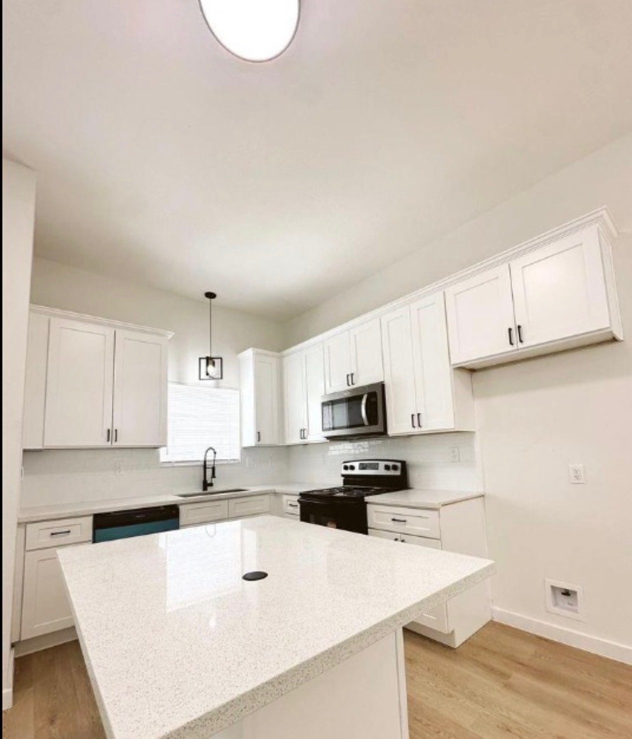 9705 Garcroft Street, Unit A Houston, TX 77029 - Photo 4 of 12 a kitchen with kitchen island a white counter top space cabinets and stainless steel appliances