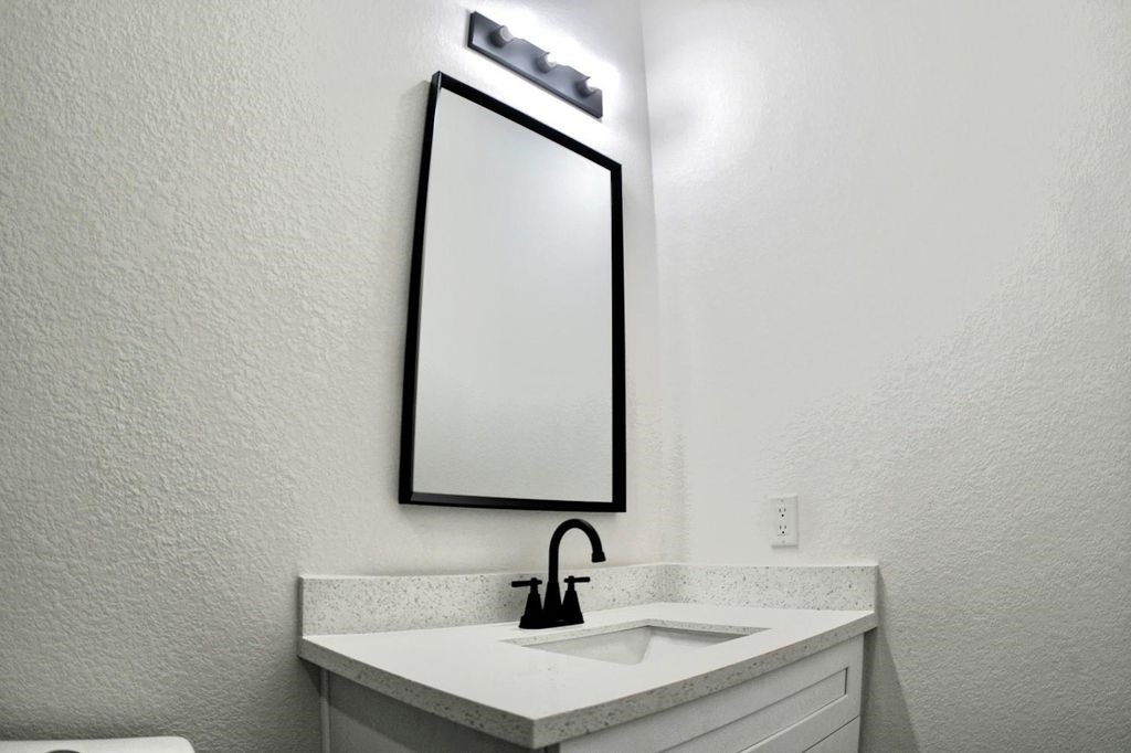 9705 Garcroft Street, Unit A Houston, TX 77029 - Photo 10 of 12 a bathroom with a sink and mirror