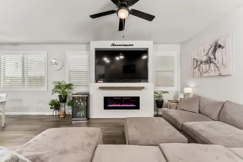 a bedroom with a bed a flat screen tv and a large window