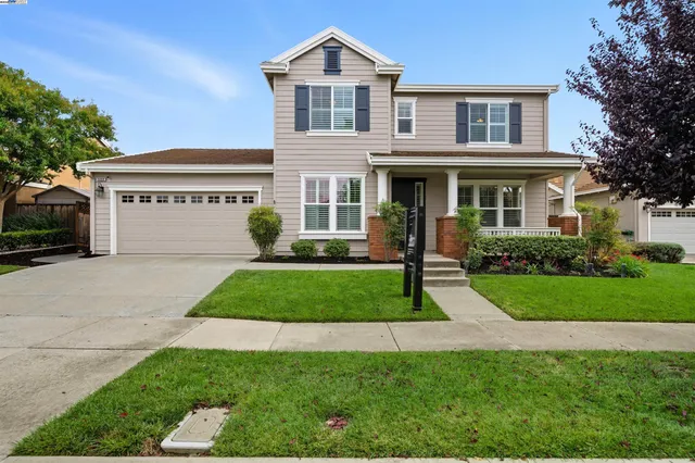 a front view of a house with a garden and plants