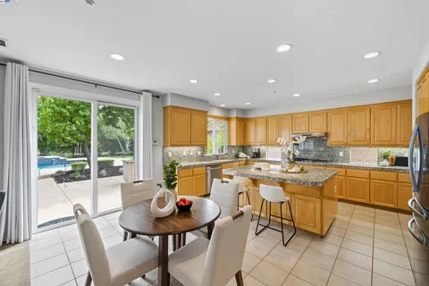 a kitchen with granite countertop a sink window and cabinets