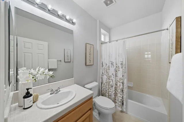 a bathroom with a double vanity sink a large mirror and a bathtub