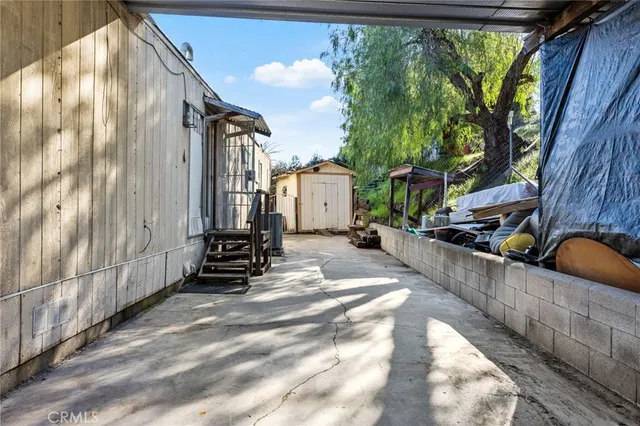 a backyard of a house with plants and wooden fence