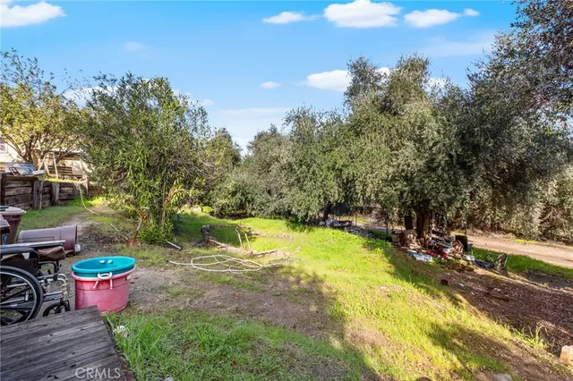 a view of a house with pool and trees in the background