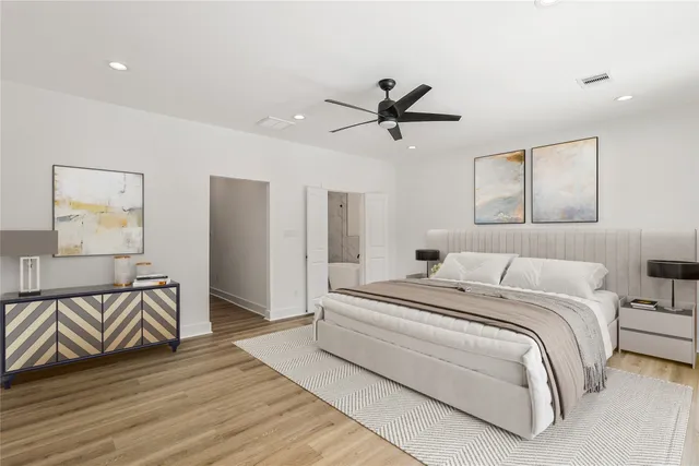 a bedroom with a bed and painting on the wall