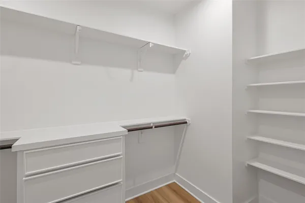 a view of walk in closet with empty racks
