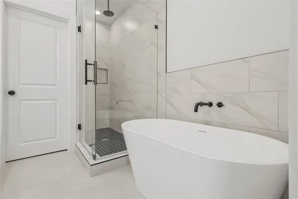 a white bath tub sitting next to a shower