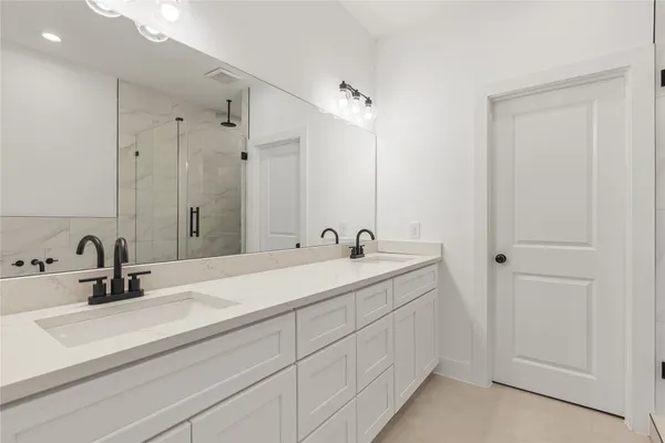 a bathroom with double sink and a mirror