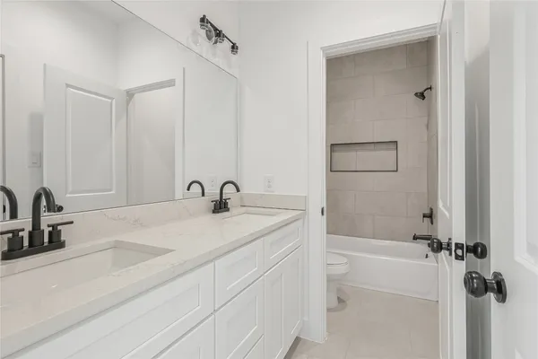 a bathroom with a granite countertop sink a toilet and shower