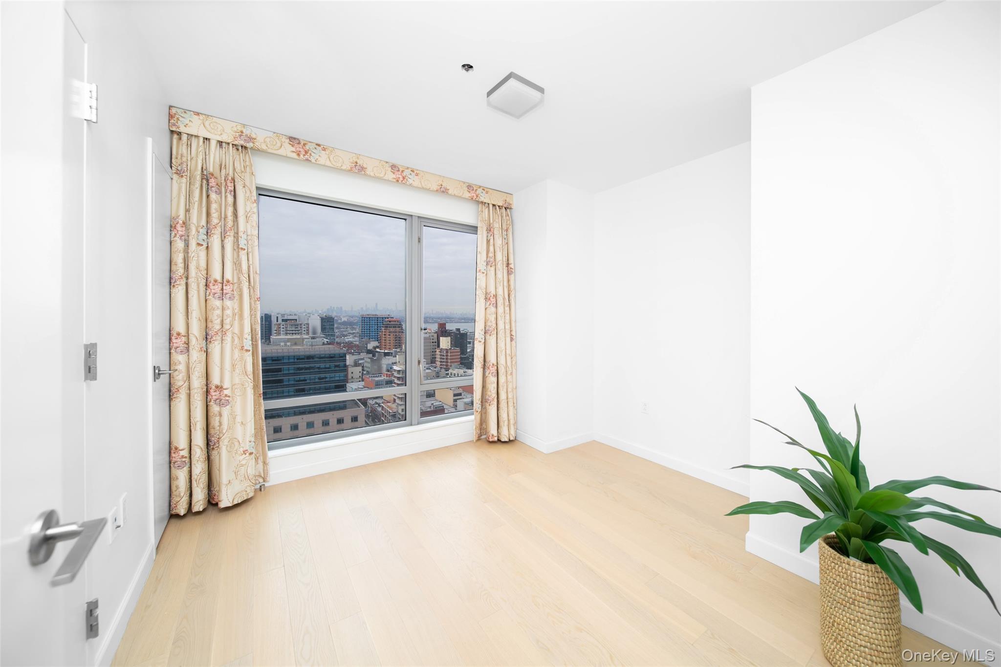 138-35 39th Avenue, Unit 17H Queens, NY 11354 - Photo 20 of 36 a view of an empty room with a potted plant