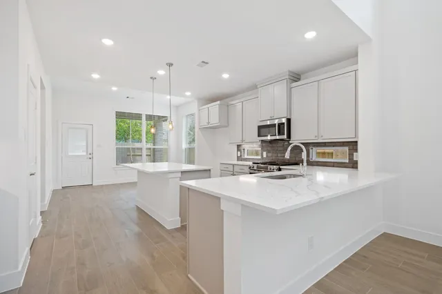 a kitchen with a sink a counter top space stainless steel appliances and cabinets