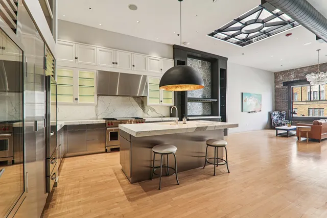 a open kitchen with stainless steel appliances kitchen island granite countertop a refrigerator a sink and a stove