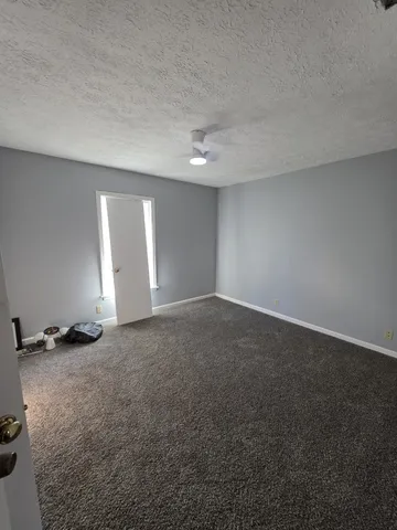 an empty room with windows and fireplace