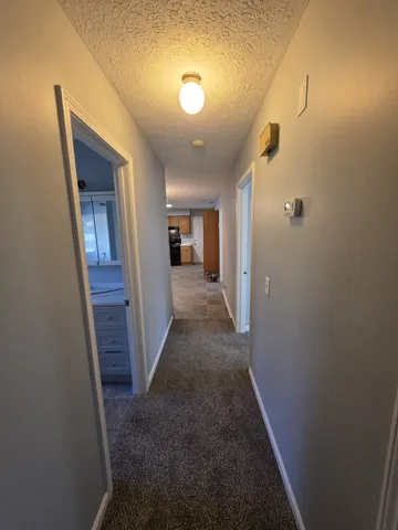 a view of a hallway with wooden shelves