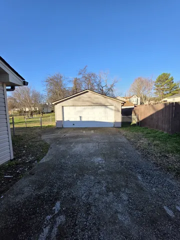 a view of a big yard with wooden fence