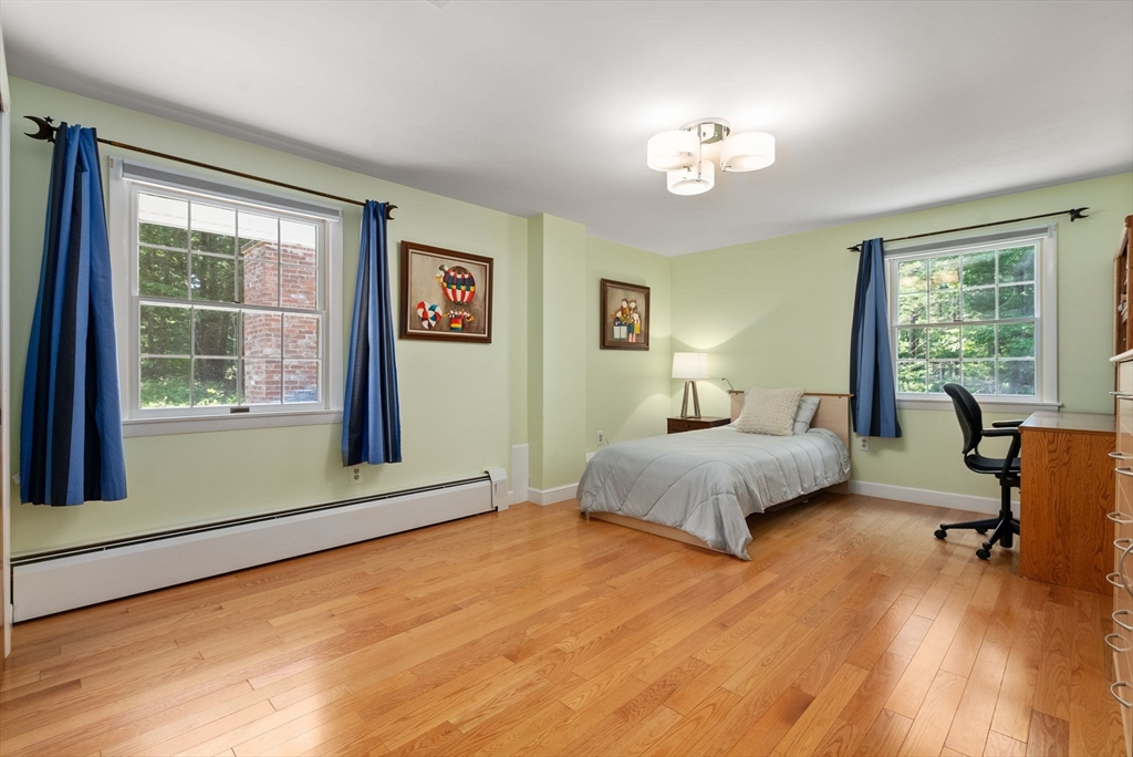 51 3 Ponds Road Wayland, MA 01778 - Photo 15 of 22 a spacious bedroom with a large bed and a chandelier
