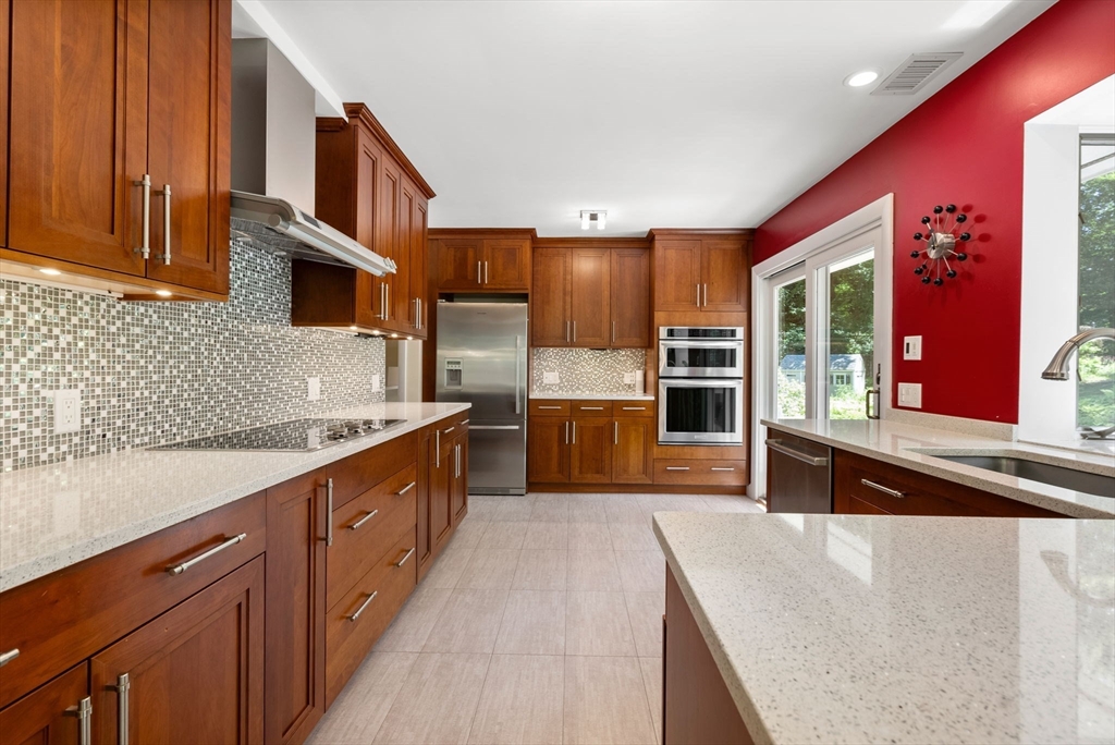 51 3 Ponds Road Wayland, MA 01778 - Photo 2 of 22 a large kitchen with stainless steel appliances granite countertop a large stove top oven a refrigerator a sink and dishwasher with wooden cabinets
