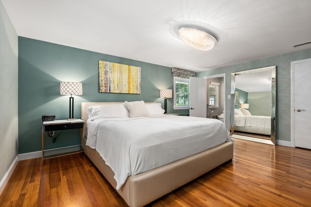 51 3 Ponds Road Wayland, MA 01778 - Photo 7 of 22 a bedroom with a bed and a mirror