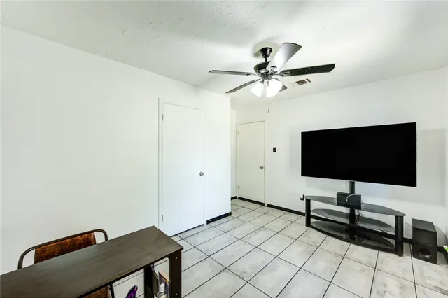 a view of workspace with wooden floor and fan
