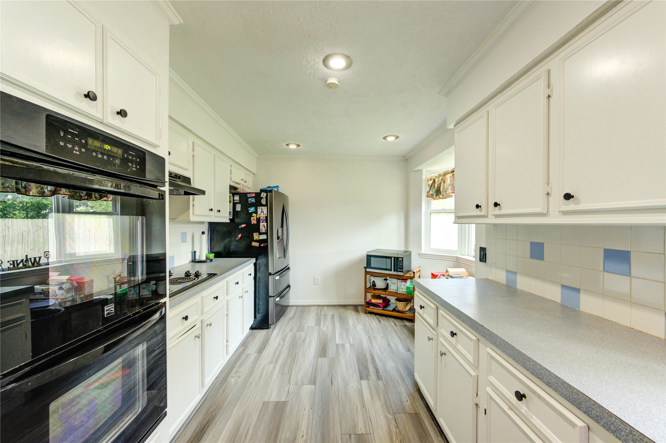 21014 Cimarron Parkway Katy, TX 77450 - Photo 9 of 21 a kitchen with kitchen island granite countertop a sink dishwasher stove and white cabinets with wooden floor