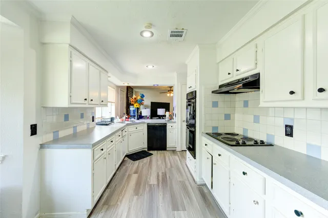 a kitchen with granite countertop a refrigerator and a stove top oven