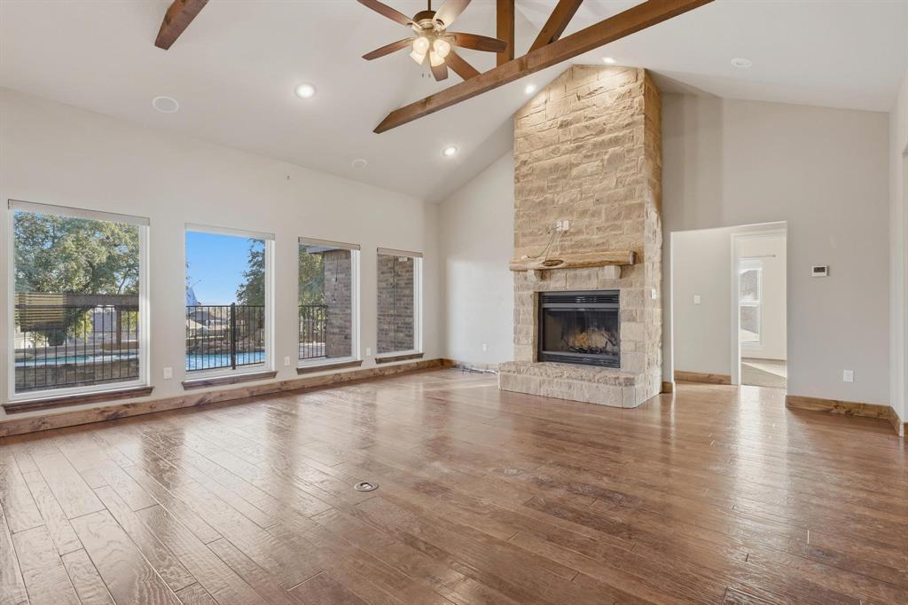 109 Benton Tuscola, TX 79562 - Photo 4 of 40 an empty room with wooden floor fireplace and windows