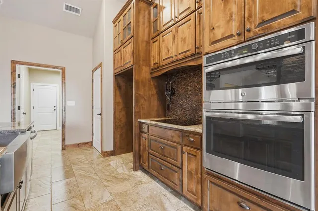 a kitchen with stainless steel appliances kitchen island granite countertop a stove and a microwave oven