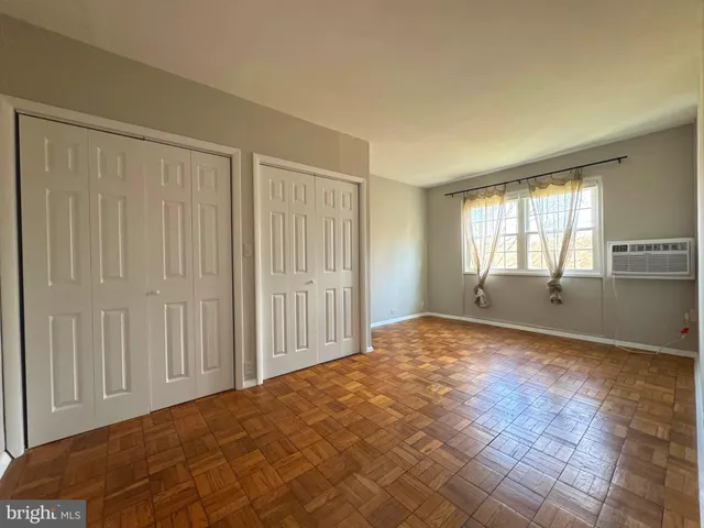 a view of an empty room and window and wooden floor