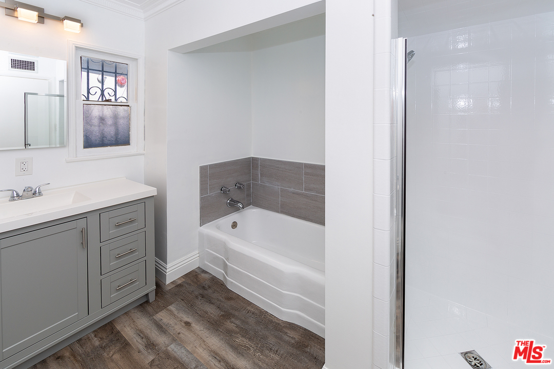 9428 Duxbury Road Los Angeles, CA 90034 - Photo 11 of 17 a bathroom with a tub sink and a mirror