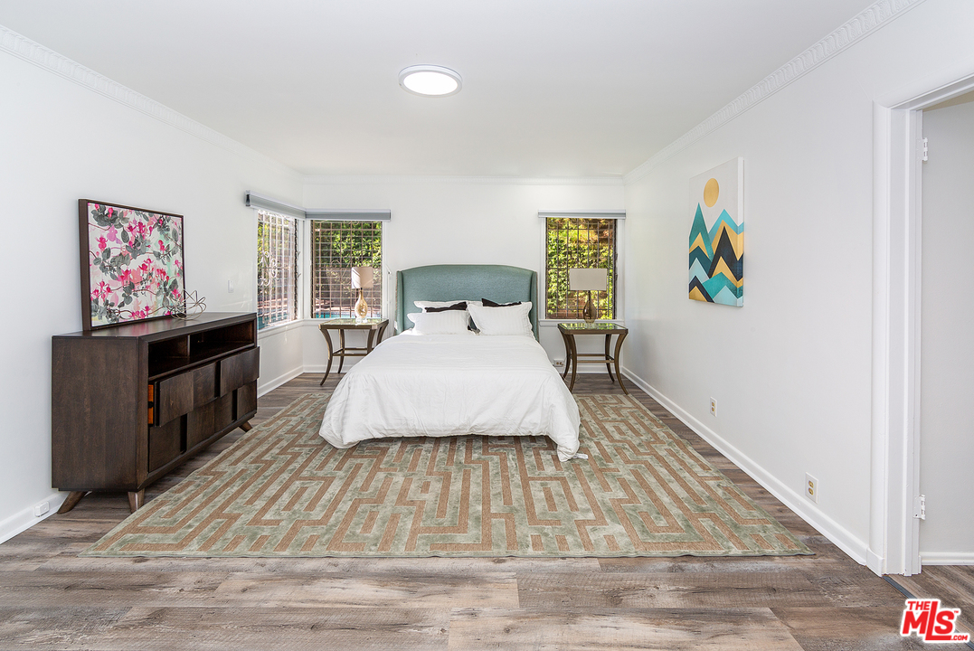 9428 Duxbury Road Los Angeles, CA 90034 - Photo 12 of 17 a spacious bedroom with a bed and wooden floor