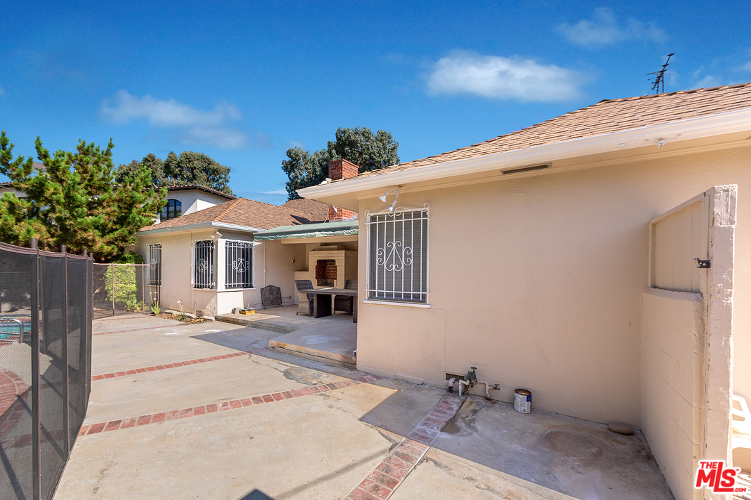 9428 Duxbury Road Los Angeles, CA 90034 - Photo 17 of 17 a patio with a table and chairs under an umbrella